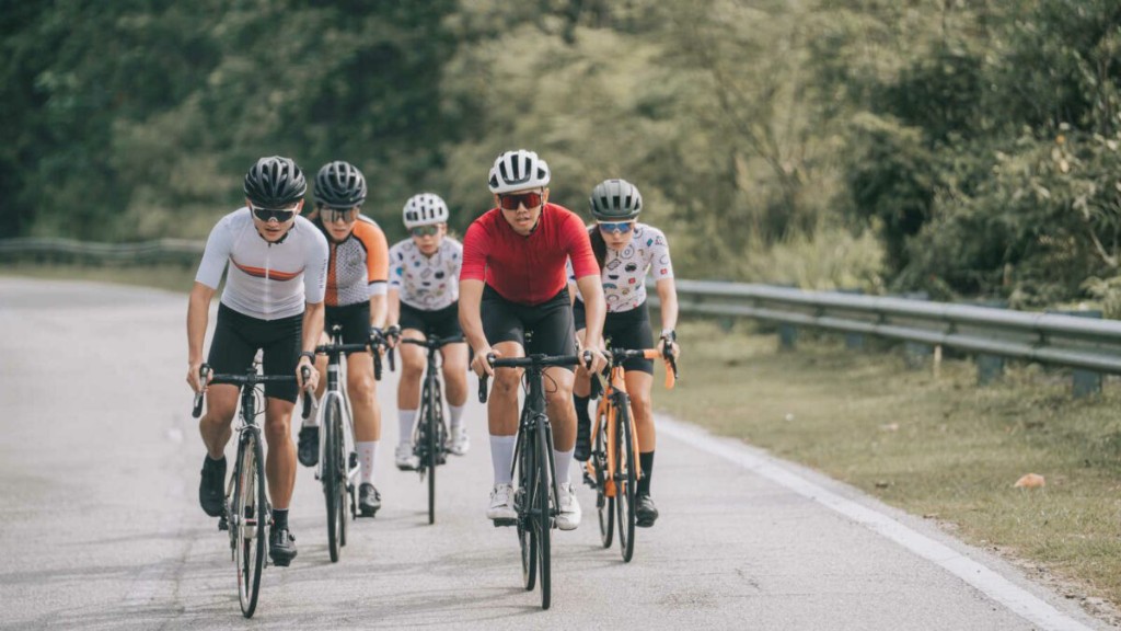 Group of cyclists riding together on a sunny road